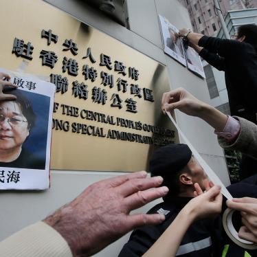 Protesters stick photos of Gui Minhai, left, and other missing booksellers outside the Liaison Office of the Central People's Government in Hong Kong on January 3, 2016.