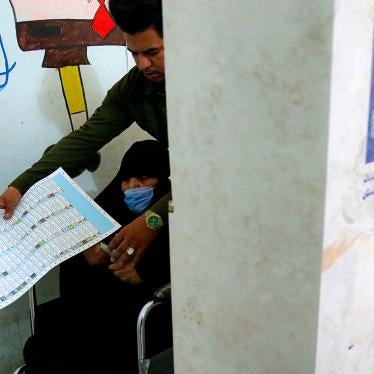 A man helps his mother as she casts her ballot during the parliamentary elections in Basra, Iraq on October 10, 2021.