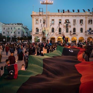 People carry a Libyan flag at Martyr square during a march commemorating the anniversary of protests in Tripoli, Libya, February 25, 2020. 
