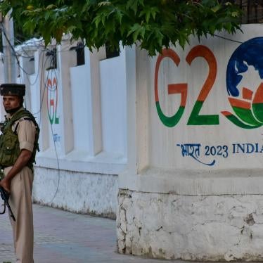 An Indian paramilitary trooper stands in front of a wall painted with the G20 logo on May 23, 2023, in Kashmir, India. 