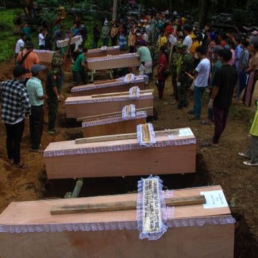 Coffins lined up beside graves at a mass funeral for victims of a Myanmar military strike on a village near Laiza, Myanmar, October 10, 2023.
