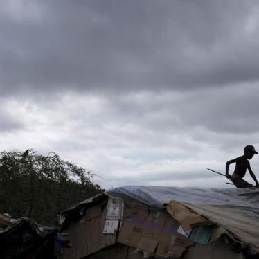 A boy fixes the roof of a makeshift tent at a refugee camp for Haitians returning from the Dominican Republic on the outskirts of Anse-a-Pitres, Haiti, September 6, 2015.