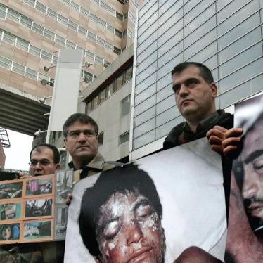 Protesters, with photos of victims killed in chemical attacks in Iraq, gather outside the district courthouse in The Hague on November 21, 2005, as the trial opens against Dutch businessman Frans van Anraat. The court convicted Van Anraat of complicity in