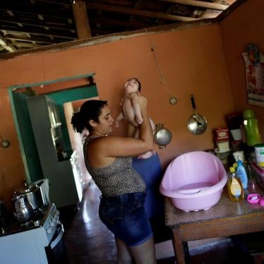 Raquel bathes her daughter Heloisa, a girl with Zika syndrome born in April 2016. Raquel says she cannot afford the medicines her twin daughters need for convulsions. 