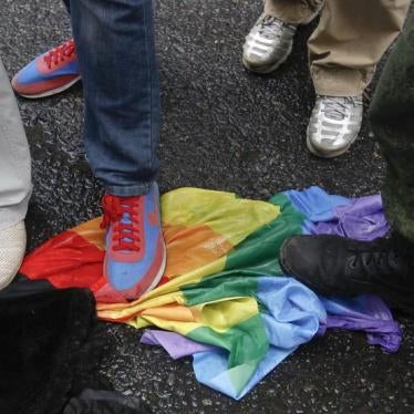 Anti-gay rights activists stand on a rainbow flag during a protest by gay rights activists demonstrating against a proposed new law termed by the State Duma, the lower house of Parliament, as "against advocating the rejection of traditional family values"