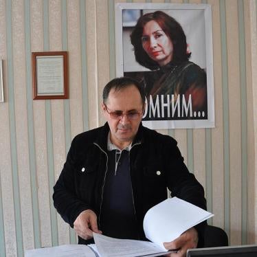 Oyub Titiev stands in front of a portrait of his murdered colleague, Natalia Estemirova, in Memorial's Grozny office, Grozny, Chechnya, Russia. 