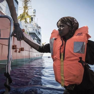 SOS MEDITERRANEE rescuers help a Somali woman off their rigid-hulled inflatable boat (RHIB) so she can board the Aquarius.