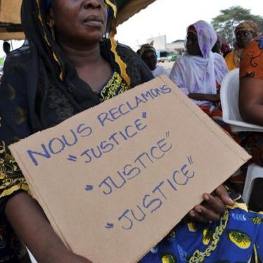 Victims of the 2010-11 post-election crisis hold placards reading 'We claim justice, justice justice' at a gathering in the Kouassai district of Abidjan on February 28, 2013, during the International Criminal Court’s confirmation of charges hearing agains