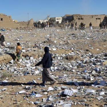 Boys walk on textbooks scattered on the ground after an air strike hit a school book storage building in the northwestern city of Saada, Yemen January 13, 2018.